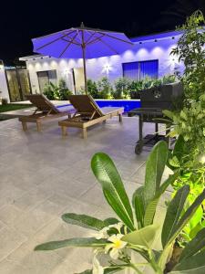 a patio with benches and an umbrella and a piano at شاليهات دبليو العمارية in Al ‘Ammārīyah