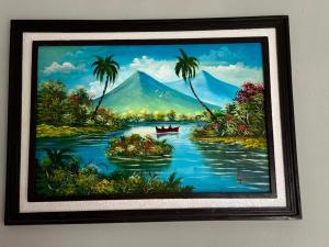 a painting of a river with palm trees and a boat at EL Viajero ll in Estelí