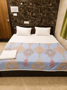 a bed with a blue comforter and white pillows at Shri Shyam Kunj Hotel in Ambikāpur +6 photos