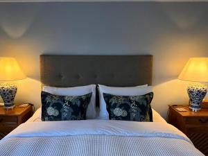 a bedroom with a bed with pillows and two lamps at The Boat House Studio in Tairua