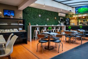 a restaurant with tables and chairs and a green wall at Pocitos Plaza Hotel in Montevideo