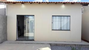 a white house with a door and two windows at Lar doce lar in Paragominas