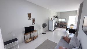 a white living room with a couch and a kitchen at Lar doce lar in Paragominas