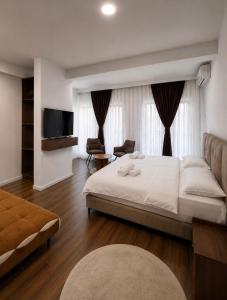 a bedroom with a large white bed and a television at Euro Hotel in Peje