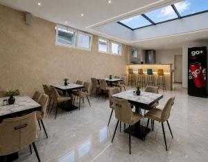a dining room with tables and chairs and a window at Euro Hotel in Peje