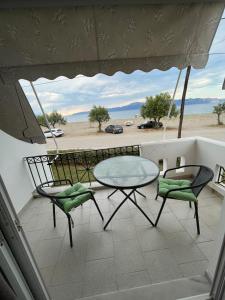 a balcony with a table and chairs and a view of the desert at Alisaxni Studios in Pefki