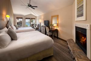 ein Hotelzimmer mit zwei Betten und einem Kamin in der Unterkunft Cottage Inn by the Sea in Pismo Beach + 21 Fotos