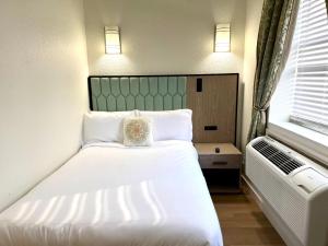 a bedroom with a large white bed and a window at Athens Hotel & Suites in Houston