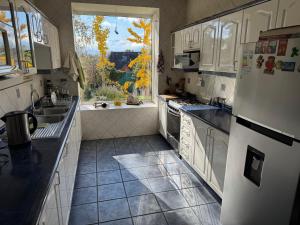 a kitchen with white appliances and a window at Casa Super Vista a los Andes in Santiago