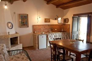 a kitchen and dining room with a wooden table and a table and a tableablish at Agosud Casa vacanze in Marzamemi