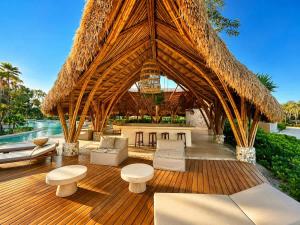 a pavilion with chairs and tables and a straw roof at Mayan View Walk to Beach & Tulum Ruins in Tulum