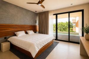 a bedroom with a large bed and a large window at Mayan View Walk to Beach & Tulum Ruins in Tulum