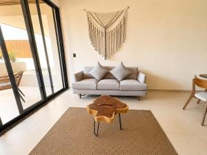 a living room with a couch and a table at Mayan View Walk to Beach & Tulum Ruins in Tulum