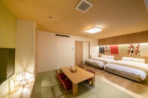 a bedroom with a large bed and a table at Kyoto Central Inn in Kyoto