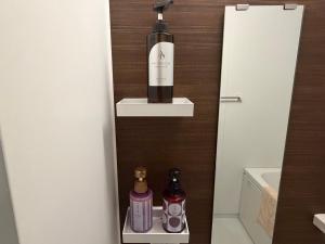 a bottle of wine on a shelf in a bathroom at Kyoto Central Inn in Kyoto
