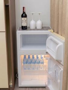 an open refrigerator with a bottle of wine and drinks at Room in sliema's heart in Il-Gżira