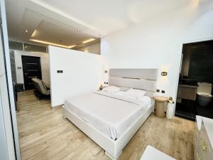 a white bedroom with a bed and a bathroom at Appartement à Cotonou in Cotonou