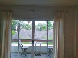 a room with a balcony with a table and chairs at THAMONWAN hostel in Cha Am