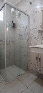 a shower with a glass door in a bathroom at Quarto Casal Cinza in Artur Nogueira