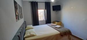a bedroom with a bed with two towels on it at Quarto Casal Cinza in Artur Nogueira