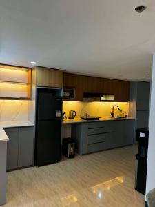 a large kitchen with a black refrigerator and cabinets at Luxury Loft at Crown Regency in Cebu City