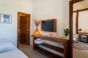 a bedroom with a television on a wooden table at Villa Florens in Jericoacoara