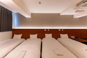 two beds are lined up in a room at COCOSHUKU Tokyo Nakano in Tokyo