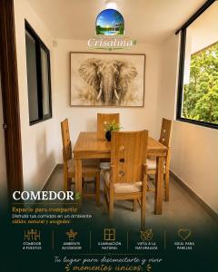 a dining room with a table and chairs and an elephant picture at crisalma 1 in La Tebaida