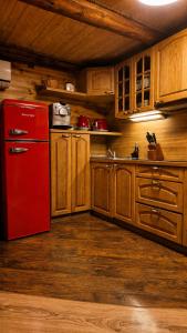 a kitchen with a red refrigerator and wooden cabinets at The DACHA escape in Viimsi