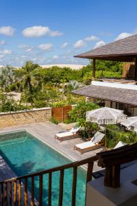 a balcony with a swimming pool and chairs at Villa Florens in Jericoacoara