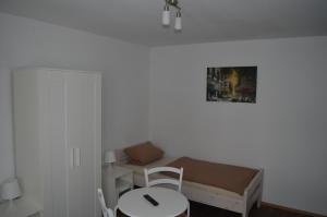 a small bedroom with a bed and a table at Pension John-F-Kennedy in Kassel