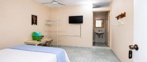 a bedroom with a bed and a tv on the wall at Hospedaje doña Gladys in Flores