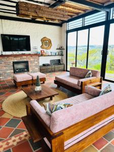 a living room with couches and a fireplace at Casa Luna Hotel Campestre & Spa in San Gil