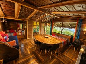 a living room with a wooden table and a bed at El Sol Monteverde in Monteverde Costa Rica
