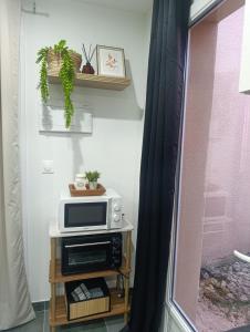a microwave on a table next to a window at Studio cosy Boulazac in Boulazac