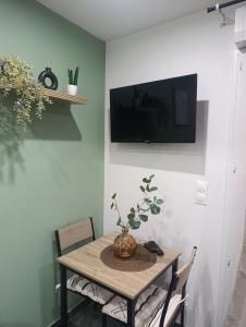 a dining room table with a television on a wall at Studio cosy Boulazac in Boulazac +8 photos