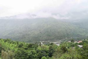 a view of a mountain with a town in the foreground at Hotel O Dp Bar in Rāmpur