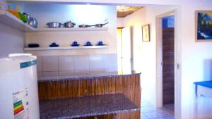 Pousada Recanto do Sossego في إيتاماراكا: مطبخ مع منضدة مع أطباق زرقاء على الحائط