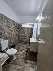 a bathroom with a toilet and a sink at El Ñangapiri in Mercedes +11 photos