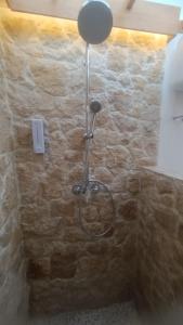 a shower in a stone wall with a hose at Morgans Bungalows in Maluk