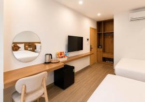 a hotel room with a desk and a bed and a mirror at Anna seaview hotel in Phú Quốc