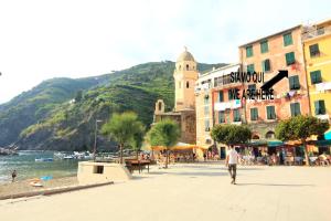 a man walking down a street next to a beach at Vernazza Vacation 2 in Vernazza