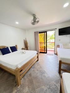 a bedroom with two beds and a balcony at Hotel Heliopolis in Coveñas +61 photos