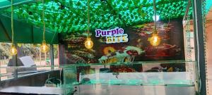 a burger shop with green lights in the window at Mr smith hotel in Oyarifa