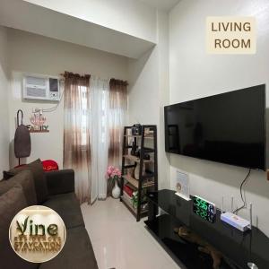 a living room with a large flat screen tv at Vine Residences Staycation in Manila