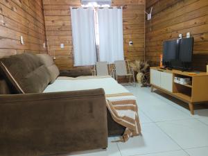 a living room with a bed and a television at Casa da Brisa in Salinópolis
