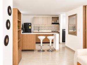 a kitchen with two white stools in a room at Apartamento Armenia in Armenia
