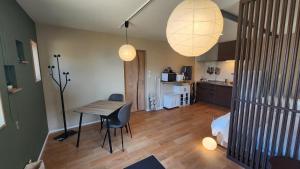 a living room with a table and a kitchen at Tiny House Iyashirochi Kaze in Miyoshi
