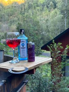 a bottle of alcohol and a glass of wine on a table at Casa Salto Pichi Ignao in Lago Ranco