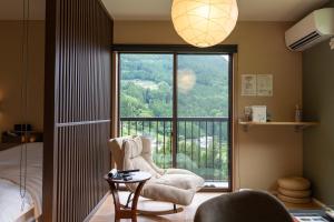 a bedroom with a large window with a view of a mountain at Tiny House Iyashirochi Kaze in Miyoshi